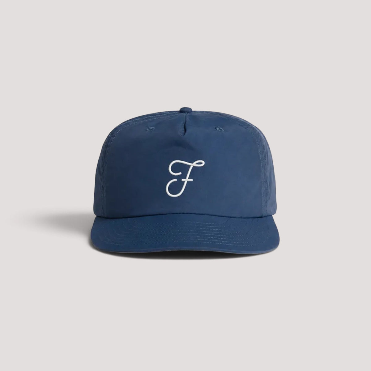 A navy blue hat with a white embroidered cursive 'F' logo on the front, set against a light gray background.