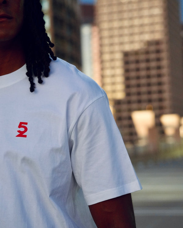 Close-up of the small red "52" print on the front chest of the Be My Caddie Tee.