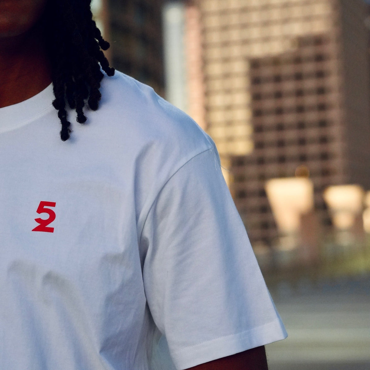 Close-up of the small red "52" print on the front chest of the Be My Caddie Tee.