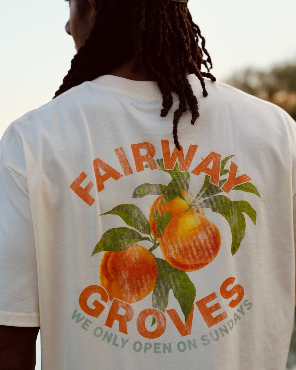 Close-up of the Fairway Groves Tee's back graphic — an orange tree illustration with "Fairway Groves, We Only Open On Sundays."