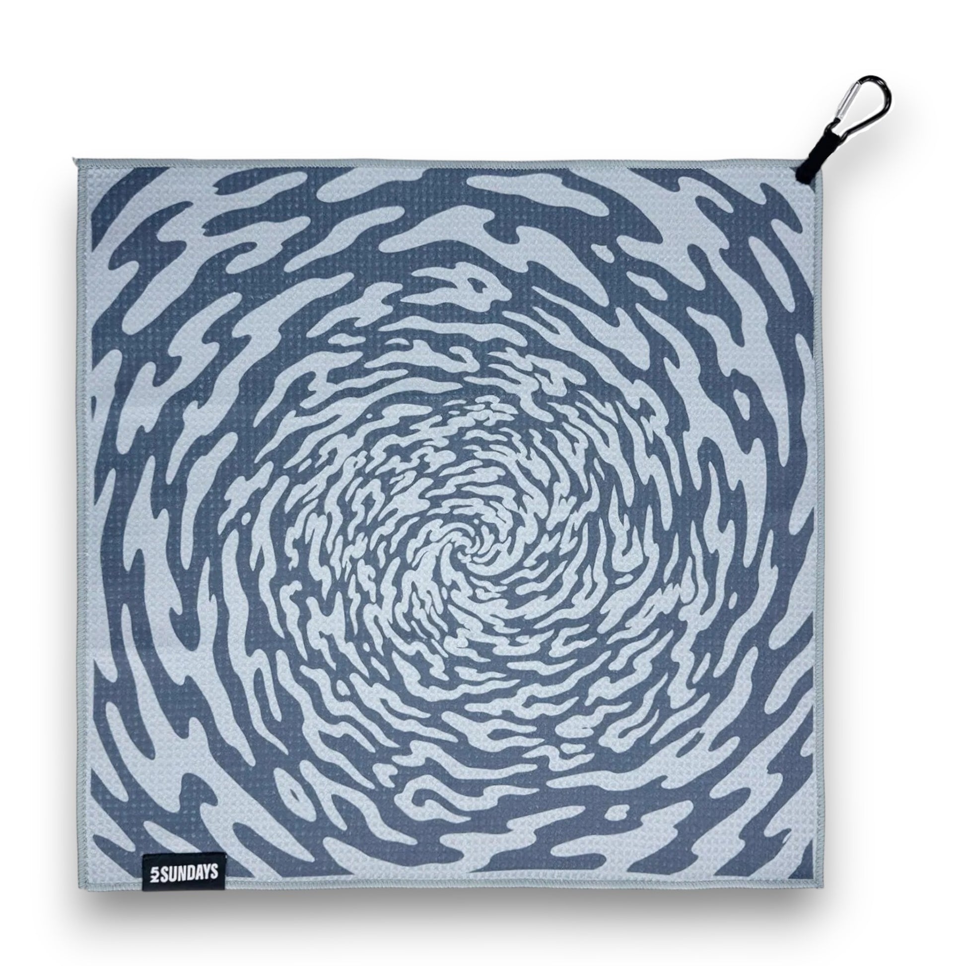 A square fabric golf towel with a blue and white spiral pattern, featuring a black carabiner clip on the top right and a black brand label on the bottom left.