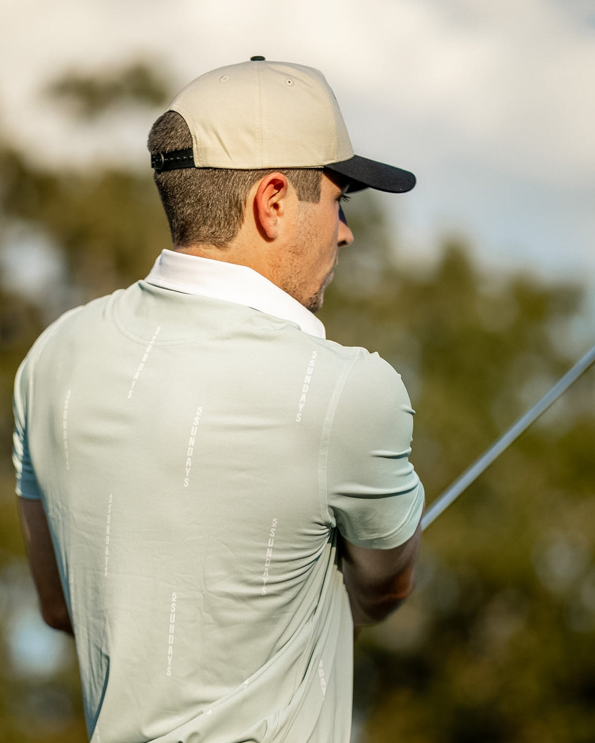 Back of the Hermosa Sage Polo showing the vertical 52 SUNDAYS print.