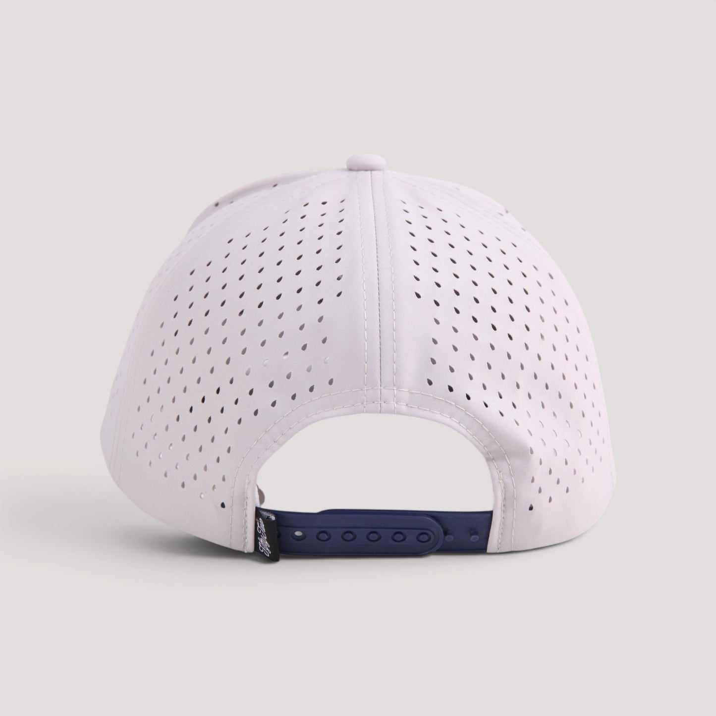 Golf hat with perforated side panels and a navy blue adjustable strap, shown from the back on a light gray background.