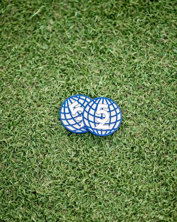 Two 52 Sundays navy globe-design golf ball markers resting on artificial turf, showing the '52' logo detail